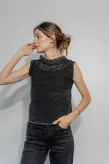 Top tejido negro con hilo brillante, cuello alto con trenzado y espalda baja.