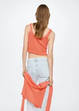 Top color salmón de tejido de punto fino con diseño entallado y crop. Tiene cuello escotado, tirantes anchos y terminaciones festoneadas.