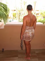Vestido corto con estampado animal print en tonos marrones y blancos, con escote halter pronunciado y espalda descubierta.