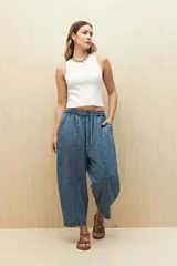Pantalón de denim celeste, corte amplio, con cintura elástica ajustable con cordón.