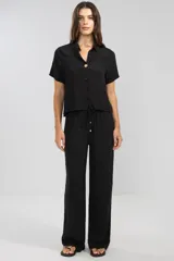 Pantalón negro de crepe con cintura elastizada, corte recto y bolsillos laterales.