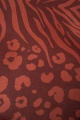 Cooler pequeña con estampado animal print en tonos chocolate. Tiene manija jacquard con el monograma Polonio, cierre invisible y el interior sellado.