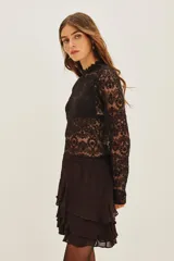 Falda corta negra con múltiples capas de volados en el ruedo.