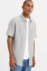 Camisa de manga corta a rayas verticales grises y blancas con bolsillo en el pecho izquierdo y logo de la marca en rojo.