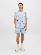 Short de baño celeste con estampado de flores blancas, amarillas y verdes. Tiene cintura elástica con cordón ajustable, bolsillos laterales y logo de la marca en la pierna derecha.