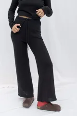 Pantalón negro de punto con corte recto y cintura con cordón ajustable.