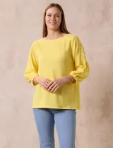 Blusa blanca texturada marca Ruby Rd, con escote redondo y mangas 3/4 con puño elastizado y apliques de broderie. Confeccionada en poliéster y elastano.