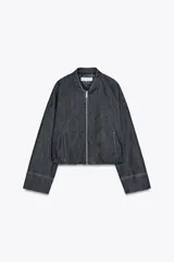 Cazadora bomber de denim color gris oscuro, con cuello redondo, cierre frontal con cremallera metálica, bolsillos laterales y mangas largas con puños elásticos.