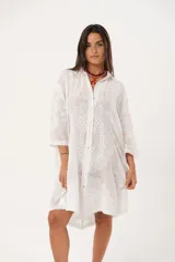 Camisola blanca con bordado de flores, cuello camisero, mangas 3/4 y cierre frontal con botones.