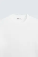 Jersey de punto color marrón oscuro, de corte relajado (relaxed fit), con cuello redondo y manga corta.