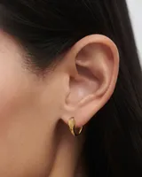 Aros de oro con forma de lágrima y piedra blanca.