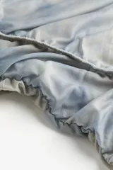Vestido midi de malla con estampado tie-dye en tonos celeste y blanco. Modelo entallado de manga larga con escote amplio y costuras fruncidas. Ribete decorativo adelante y en las mangas. Viso de punto con breteles finos y escote redondo profundo.