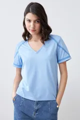 Remera celeste melange de corte clásico, con escote en V y mangas cortas con detalle de costuras en contraste.