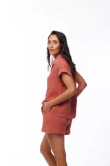 Camisa color ladrillo de algodón con cuello clásico, manga corta con dobladillo y cierre frontal con botones.