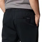 Pantalón de trekking negro con corte tapered, tejido resistente al agua y a las manchas, cintura elástica, bolsillos delanteros, bolsillo de seguridad, dobladillo elástico, entrepierna reforzada, pierna acampanada y bolsillo trasero con botón de presión.