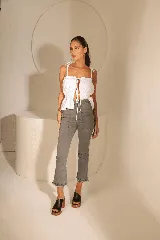 Blusa blanca de lino con frunces generados por tiras y breteles regulables.