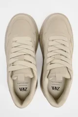 Zapatillas deportivas color beige con plataforma de 6 cm y cierre con cordones.
