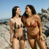 Conjunto de bikini de rayas verticales en tonos marrón, verde, naranja y amarillo. El corpiño es de triángulo con tirantes finos y la braguita es de corte clásico.