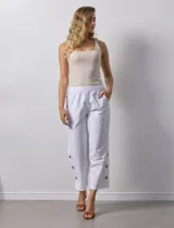 Pantalón blanco de algodón con pretina elastizada, bolsillos inclinados y ruedo con botones.