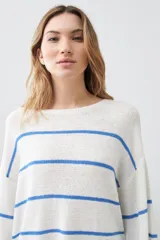 Sweater de punto color blanco con rayas horizontales azules, de corte holgado y mangas largas acampanadas.