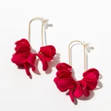 Aros colgantes con forma de gota, color fucsia, con estructura dorada.