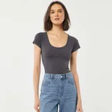 Remera gris de corte ajustado, con escote redondo pronunciado y mangas cortas.