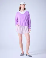 Sweater negro de cashmere cepillada con cuello en V, corte oversize, mangas largas y terminaciones acanaladas.