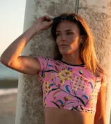 Top corto de lycra reciclada con estampado floral, mangas cortas y espalda abierta.