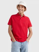 Chomba roja Tommy Hilfiger 1985 de corte regular, con cuello tipo chomba, cartera de dos botones, logo de Tommy Hilfiger bordado en el pecho y detalles distintivos de la marca.