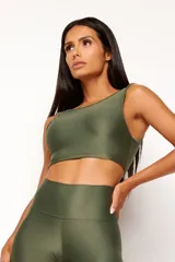 Top deportivo color ladrillo, de poliamida con acabado brillante y textura acanalada, con cuello redondo y espalda escotada.