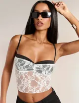 Top de encaje blanco con forro negro, breteles finos y escote corazón.