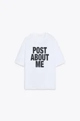 Camiseta blanca de corte amplio, cuello redondo y mangas cortas. Estampado frontal con la frase "Post About Me" en letras negras.
