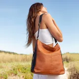 Cartera negra de simil cuero con apertura superior con cierre. Tiene detalle frontal en costura, dos bolsillos internos, un bolsillo divisor en el forro y bolsillos laterales con cierre. Incluye correa larga regulable.