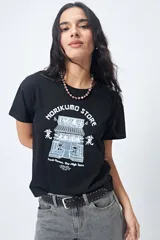 Remera negra de algodón con estampado blanco de un edificio de estilo oriental y texto en inglés y japonés.