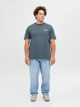 Remera azul de manga corta con cuello redondo y estampado en la espalda con la frase "ORIGINALS STUDIO Copenhagen EST.1990 Workshop CRAFTED AESTHETICS DAILY BASIC GARMENTS".