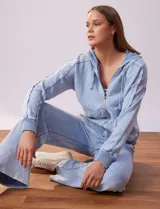 Campera de algodón celeste con capucha, cierre frontal y bolsillos aplicados. Terminación de puños y ruedo acanalado.