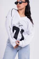 Remerón negro de corte holgado con estampado frontal del número 01 en blanco y la frase "Los Angeles" en las mangas.