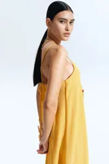 Vestido midi amarillo con textura arrugada, breteles finos y escote recto.