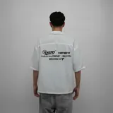 Camisa blanca de manga corta con cuello tipo cubano, corte oversize y estampado con el logo de la marca en el pecho y la espalda.