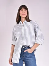 Camisa celeste y blanca a rayas verticales, de corte recto y manga 3/4.