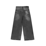 Pantalón de jean negro con lavado oscuro y efecto desgastado, de corte ultra ancho y tiro alto. Presenta un parche circular con logo en el bolsillo trasero derecho.