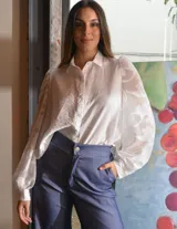 Camisa negra con estampado abstracto, mangas largas abullonadas de tul transparente y cuello camisero.
