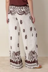 Pantalón palazzo de lino y viscosa color crudo con estampado de hojas en marrón chocolate.