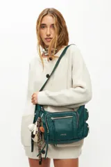 Bandolera color verde con varios bolsillos y detalles decorativos, ideal para uso diario.
