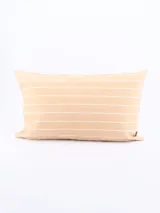 Funda de almohadón rectangular color beige con rayas horizontales blancas.