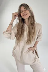 Canguro beige oversize de tejido suave con capucha, cordones ajustables y bolsillo tipo canguro.