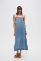 Vestido largo holgado de tela tipo denim o chambray, color azul claro, con tirantes finos y detalle de bordado o encaje en el escote. Presenta una abertura frontal central.