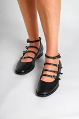 Chatas de cuero negro con punta fina, cuatro tiras horizontales con hebilla y pulsera al tobillo.
