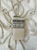 Billetera grande de cuero con estampado de reptil en tonos beige y gris. Tiene cierre metálico, forro interior y múltiples compartimentos. Incluye moneda colgante plateada con el logo de la marca.