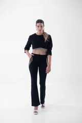 Top corto negro de mangas 3/4 con detalle de flecos de strass en el ruedo.